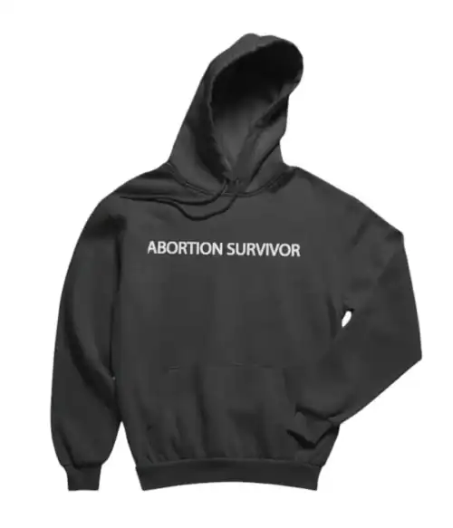 Black hoodie with bold white text "ABORTION SURVIVOR" on the front, casual streetwear fashion statement, unisex design, perfect for making a political statement or expressing personal beliefs, comfortable and trendy apparel.